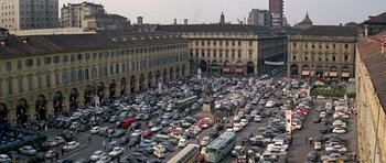 Movie still from “The Italian Job” (1969), directed by Peter Collinson – A busy street filled with lots of traffic and parked cars; Extreme Wide shot, High angle