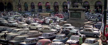 Movie still from “The Italian Job” (1969), directed by Peter Collinson – A bunch of cars are parked in a parking lot; Extreme Wide shot, High angle