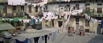 Movie still from “The Italian Job” (1969), directed by Peter Collinson – Clothes are hanging on a clothesline outside a building; Extreme Wide shot, High angle