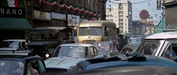 Movie still from “The Italian Job” (1969), directed by Peter Collinson – A bus driving down a busy street filled with traffic; Wide shot, High angle