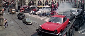Movie still from “The Italian Job” (1969), directed by Peter Collinson – A street scene with cars parked on the side of the road; Wide shot, High angle