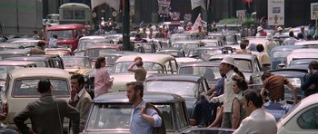 Movie still from “The Italian Job” (1969), directed by Peter Collinson – A large group of cars parked on the side of the road; Extreme Wide shot, High angle