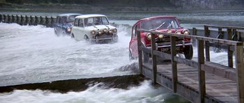 Movie still from “The Italian Job” (1969), directed by Peter Collinson – A group of cars driving through a body of water; Wide shot, High angle