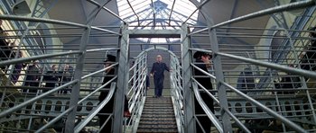 Movie still from “The Italian Job” (1969), directed by Peter Collinson – A man walking down a set of stairs; Wide shot, Low angle