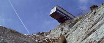 Movie still from “The Italian Job” (1969), directed by Peter Collinson – A bus that is on top of a mountain; Extreme Wide shot, High angle