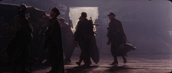 Movie still from “The Keep” (1983), directed by Michael Mann – A group of men walking through a tunnel with guns; Wide shot, High angle