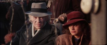 Movie still from “The Keep” (1983), directed by Michael Mann – A man and a woman wearing hats sitting next to each other; Close Up shot, High angle