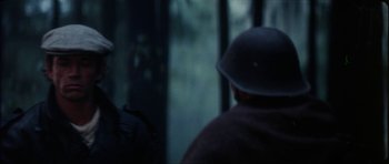 Movie still from “The Keep” (1983), directed by Michael Mann – A man wearing a helmet is looking out a window; Close Up shot, Over the shoulder angle