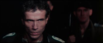 Movie still from “The Keep” (1983), directed by Michael Mann – A person wearing a black jacket; Close Up shot, Over the shoulder angle