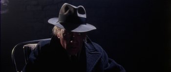 Movie still from “The Keep” (1983), directed by Michael Mann – An older man wearing a hat and a coat; Close Up shot, Low angle