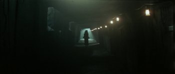 Movie still from “The Keep” (1983), directed by Michael Mann – A woman is standing in a dark tunnel; Wide shot, Low angle