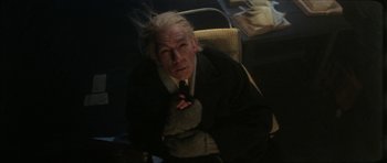 Movie still from “The Keep” (1983), directed by Michael Mann – An old man with a white hair sitting in a chair; Medium shot, High angle