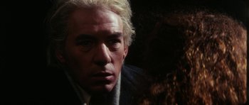 Movie still from “The Keep” (1983), directed by Michael Mann – A person wearing a suit and tie; Close Up shot, Over the shoulder angle
