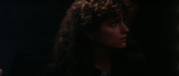 Movie still from “The Keep” (1983), directed by Michael Mann – A person with curly hair; Close Up shot, Over the shoulder angle