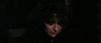 Movie still from “The Keep” (1983), directed by Michael Mann – A person with curly hair; Close Up shot, Over the shoulder angle