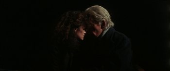 Movie still from “The Keep” (1983), directed by Michael Mann – A man and a woman standing next to each other in the dark; Close Up shot, Over the shoulder angle