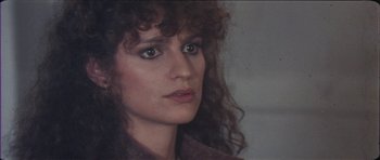 Movie still from “The Keep” (1983), directed by Michael Mann – A person with long curly hair; Close Up shot, Over the shoulder angle