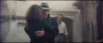 Movie still from “The Keep” (1983), directed by Michael Mann – Two men and a woman in front of a mirror; Medium shot, Over the shoulder angle