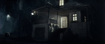 Movie still from “The Keep” (1983), directed by Michael Mann – A dark room with a balcony and stairs leading up to it; Extreme Wide shot, Low angle