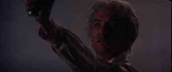 Movie still from “The Keep” (1983), directed by Michael Mann – A person holding something in his hand; Close Up shot, Low angle