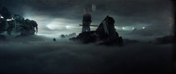 Movie still from “The Keep” (1983), directed by Michael Mann – A man standing on top of a pile of rubble; Wide shot, Low angle