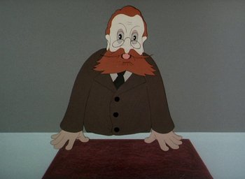 Movie still from “The King and the Mockingbird” (1980), directed by Paul Grimault – An old man with a long beard is sitting at a table; Close Up shot, Low angle