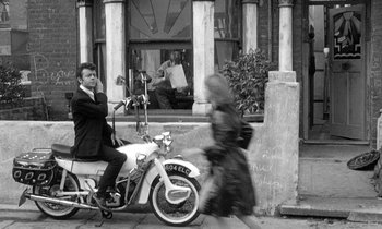 Movie still from “The Knack... and How to Get It” (1965), directed by Richard Lester – A man on a moped and a woman on a moped; Wide shot, Low angle