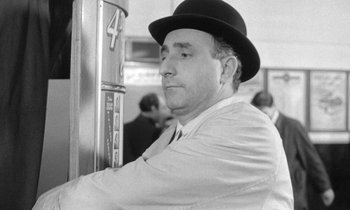 Movie still from “The Knack... and How to Get It” (1965), directed by Richard Lester – A black and white photo of a man wearing a hat; Medium shot, Low angle