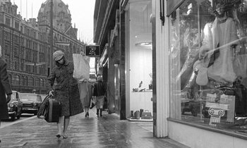 Movie still from “The Knack... and How to Get It” (1965), directed by Richard Lester – A woman walking down the street carrying luggage; Wide shot, Low angle