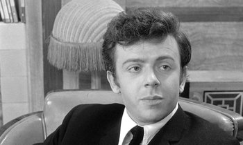 Movie still from “The Knack... and How to Get It” (1965), directed by Richard Lester – Black and white photograph of a man wearing a suit and tie; Close Up shot, Low angle