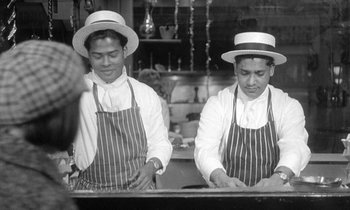 Movie still from “The Knack... and How to Get It” (1965), directed by Richard Lester – A couple of men standing next to each other in a kitchen; Medium shot, High angle