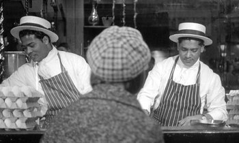 Movie still from “The Knack... and How to Get It” (1965), directed by Richard Lester – Two men wearing aprons and hats in front of a mirror; Medium shot, Over the shoulder angle