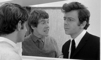 Movie still from “The Knack... and How to Get It” (1965), directed by Richard Lester – A group of young men standing next to each other in a room; Medium shot, Over the shoulder angle