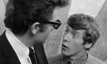 Movie still from “The Knack... and How to Get It” (1965), directed by Richard Lester – A man and a man wearing glasses looking at each other; Close Up shot, Over the shoulder angle