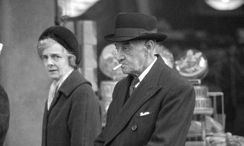 Movie still from “The Knack... and How to Get It” (1965), directed by Richard Lester – An older man and woman are smoking a cigarette; Medium shot, Low angle