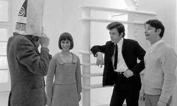 Movie still from “The Knack... and How to Get It” (1965), directed by Richard Lester – A man and a woman posing for a picture in front of another man; Medium shot, Low angle