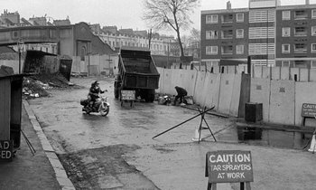 Movie still from “The Knack... and How to Get It” (1965), directed by Richard Lester – A man on a motorcycle in the rain; Wide shot, Low angle