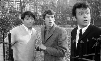 Movie still from “The Knack... and How to Get It” (1965), directed by Richard Lester – A group of men standing next to each other in a park; Medium shot, High angle