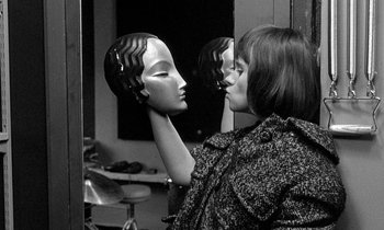 Movie still from “The Knack... and How to Get It” (1965), directed by Richard Lester – A woman holding a mask in front of a mirror; Close Up shot, Over the shoulder angle