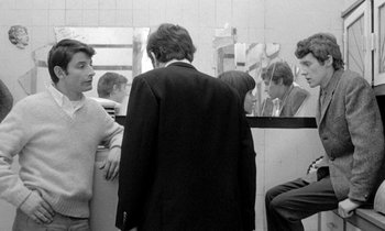 Movie still from “The Knack... and How to Get It” (1965), directed by Richard Lester – A group of men standing in front of a bathroom mirror; Medium shot, Over the shoulder angle