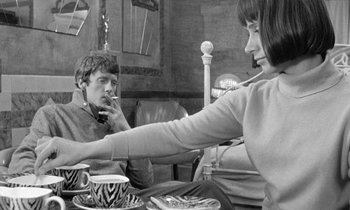 Movie still from “The Knack... and How to Get It” (1965), directed by Richard Lester – A man and a woman sitting at a table with cups; Medium shot, High angle
