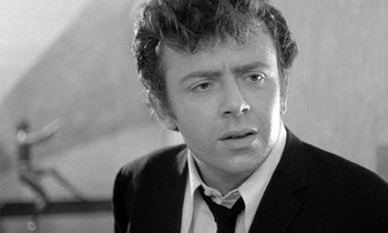 Movie still from “The Knack... and How to Get It” (1965), directed by Richard Lester – Black and white photograph of a man wearing a suit and tie; Close Up shot, Over the shoulder angle