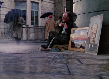 Movie still from “The Ladykillers” (1955), directed by Alexander Mackendrick – An old man sitting on the ground with an umbrella in front of him; Wide shot, Low angle