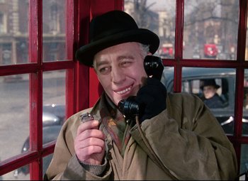 Movie still from “The Ladykillers” (1955), directed by Alexander Mackendrick – An older man talking on a phone while wearing a hat; Close Up shot, Low angle