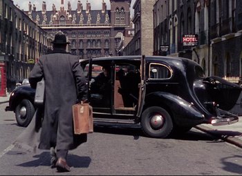 Movie still from “The Ladykillers” (1955), directed by Alexander Mackendrick – A man walking down the street with a briefcase; Wide shot, High angle