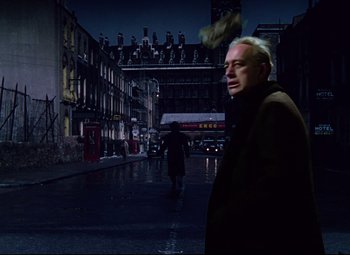 Movie still from “The Ladykillers” (1955), directed by Alexander Mackendrick – A man walking down a street at night; Medium shot, Low angle
