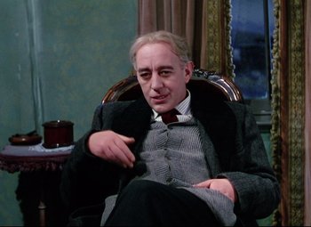 Movie still from “The Ladykillers” (1955), directed by Alexander Mackendrick – An older man sitting in a chair in a room; Medium shot, Low angle