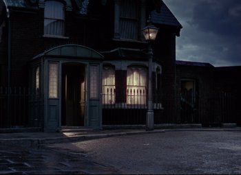 Movie still from “The Ladykillers” (1955), directed by Alexander Mackendrick – A building that is lit up at night time; Extreme Wide shot, Low angle
