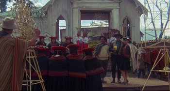 Movie still from “The Last Movie” (1971), directed by Dennis Hopper – A group of people standing in front of a building; Wide shot, High angle