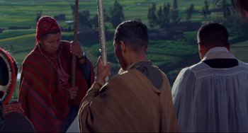 Movie still from “The Last Movie” (1971), directed by Dennis Hopper – A group of people standing next to each other on top of a hill; Medium shot, Over the shoulder angle